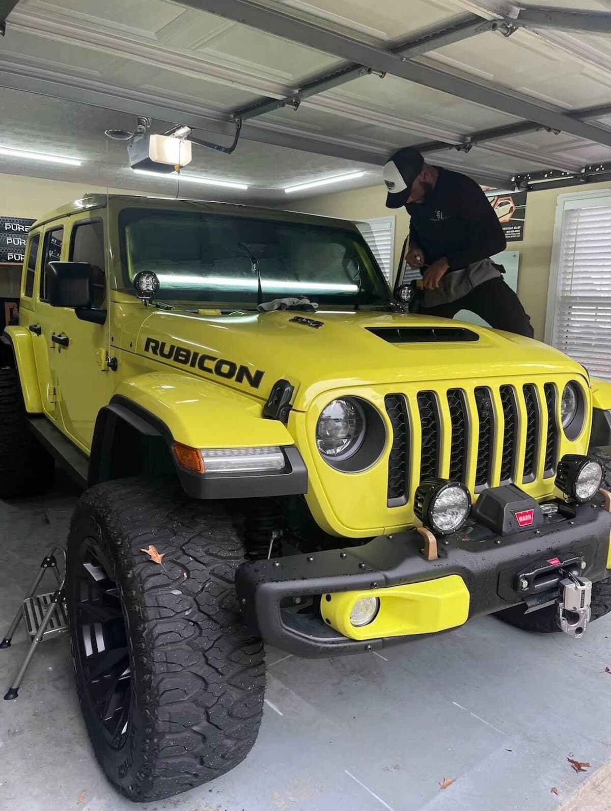 TintHut's owner installing window tint on a Jeep Wrangler Rubicon